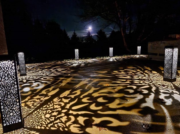 Image d'une terrasse illuminée la nuit par des lanternes à motifs